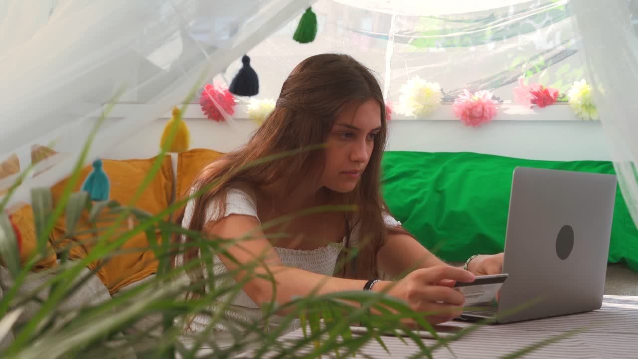 mujer alegre pagando el pedido con tarjeta de plástico durante las compras en línea