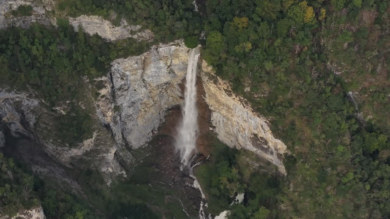 Aerial View of a Stunning Waterfall Cascading Down a Cliffside in a Lush Forest