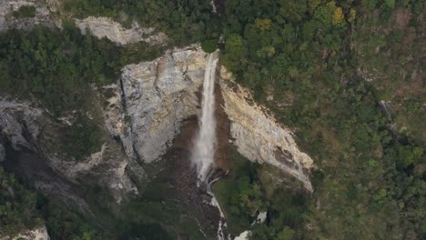 aerial view of a stunning waterfall cascading down a cliffside in a lush forest
