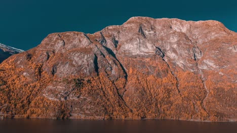 A-magnificent-mountain-towering-above-the-dark-and-still-waters-of-Oppstrynvatnet,-Norway