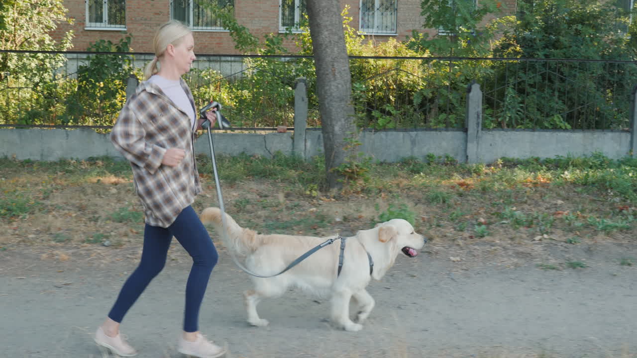 Woman jogging with her dog on a leash in an urban setting