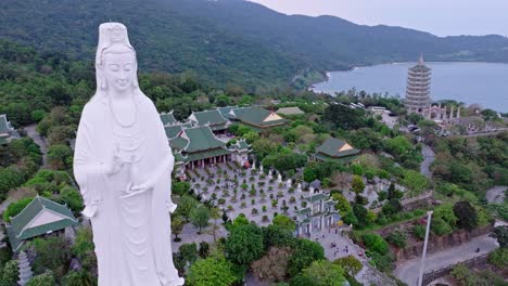 베트남 다에 있는 영감스러운 부처녀 동상은 푸른 산과 평온한 바다를 배경으로 높이 서 있습니다.