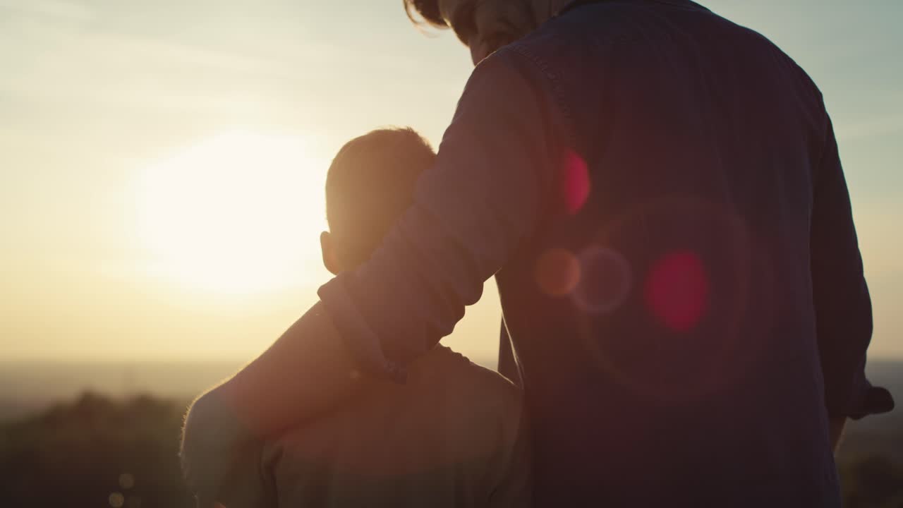 아빠와 함께 여름날 일몰을 지켜보는 작은 소년.