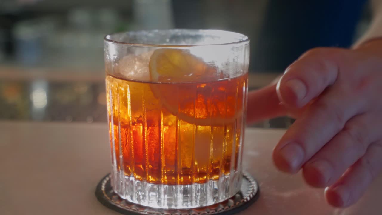 coctelero limpia una copa de cóctel iluminada