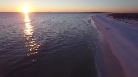 Una-Hermosa-Toma-Aérea-Sobre-Playas-De-Arena-Blanca-Al-Atardecer-Siguiendo-Pelícanos-Cerca-De-Pensacola,-Florida