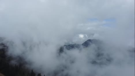 fliegen einer drohne in tief hängenden wolken hoch in den österreichischen alpen