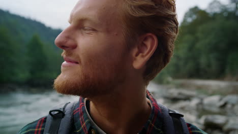 man looking at camera outdoor. tourist enjoying summer landscape in mountains