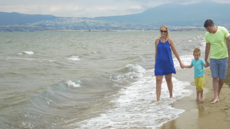 Family-with-child-walking-along-the-shore