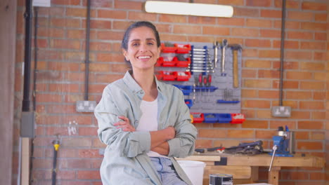 Retrato-De-Una-Mujer-Sonriente-Vestida-Informalmente-En-Un-Taller-De-Garaje-En-Casa