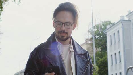 man walking and using smartphone in city