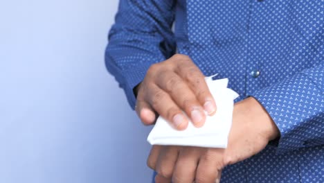 man wiping his hand with a tissue