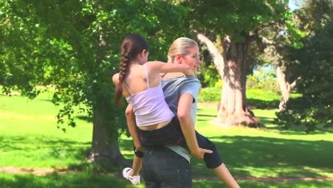 Young-mother-giving-her-daughter-a-piggyback