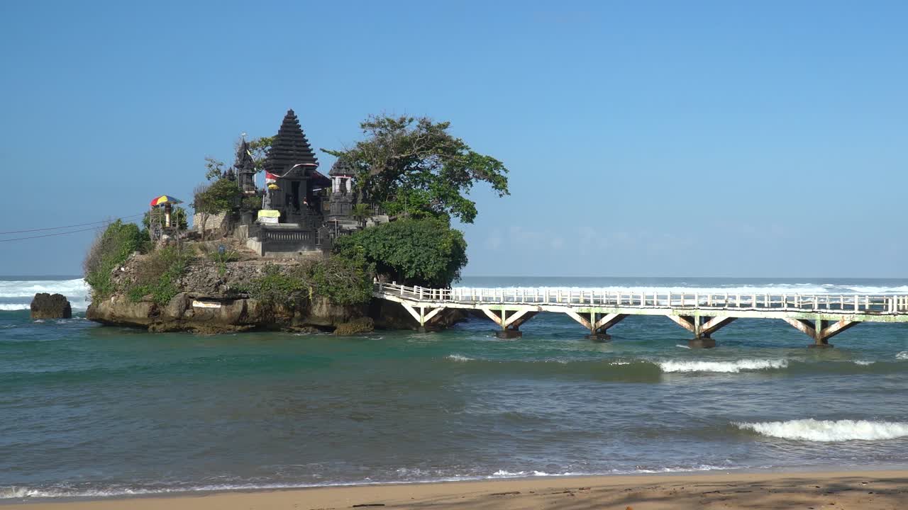 edifício solitário na ilha de praia com ponte e ondas do mar quebrando no horizonte