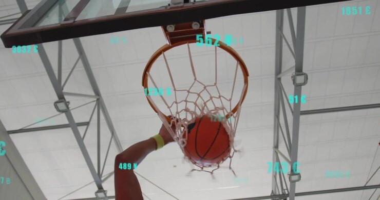 Giocatore che alza la palla da basket verso il canestro e attiva un overlay AR, mentre la rete si illumina aggiornando le metriche del tiro.