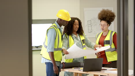 casual diverse female architects looking at 3d model in office, slow motion, copy space