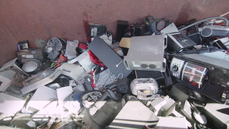 broken pc and cd player thrown onto heap of other discarded electronics