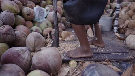 person manually husking coconuts