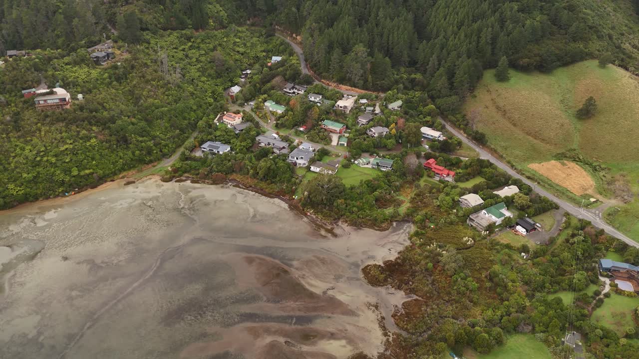 Secluded coastal community of Whatamango Bay during low tide, forest near Picton, South Island, New Zealand. Aerial top-down view
