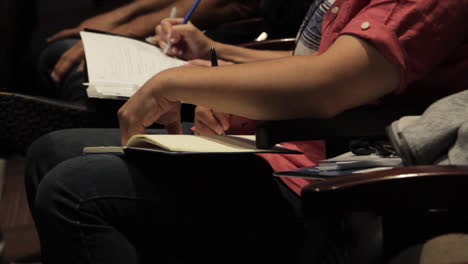 hombre latino tomando notas durante una conferencia en una conferencia