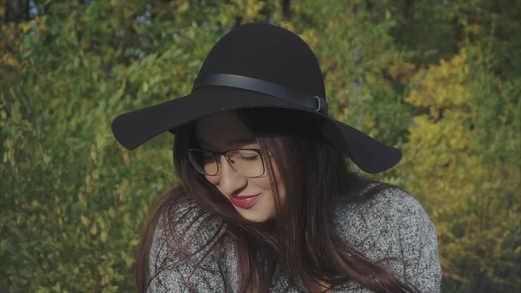 Donna con cappello nero e occhiali