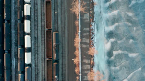 aerial shot of walking trail between train yard and frozen lake