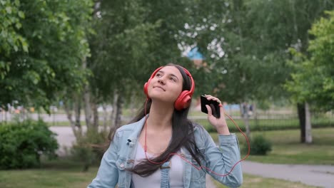 cheerful girl in headphones walks on the street