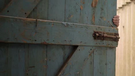 Hand-slowly-closing-old-wooden-door