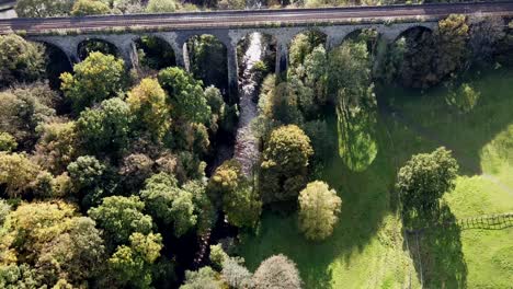 revealing aerial drone clip of river goyt passing underneath the marple aqueduct and viaduct in the united kingdom with brief purple flaring