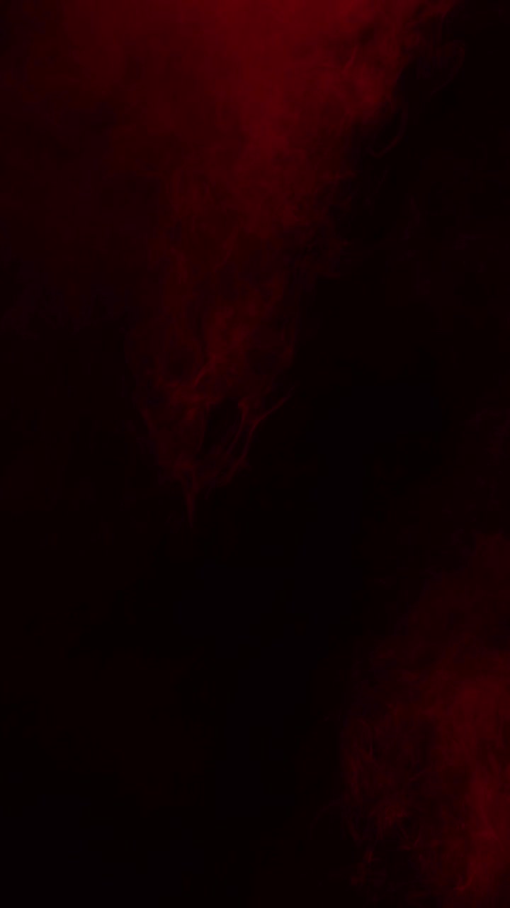 Red mist and blood swirls and flows slowly on a black background. Ideal overlay for bloody horror films, dramatic intros, atmosphere of danger or passion, vertical format