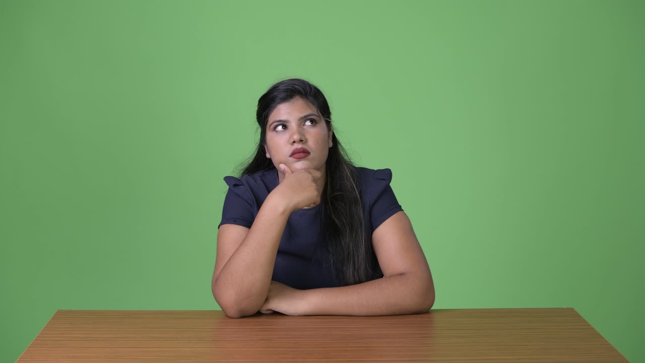 joven sobrepeso hermosa mujer de negocios india contra fondo verde