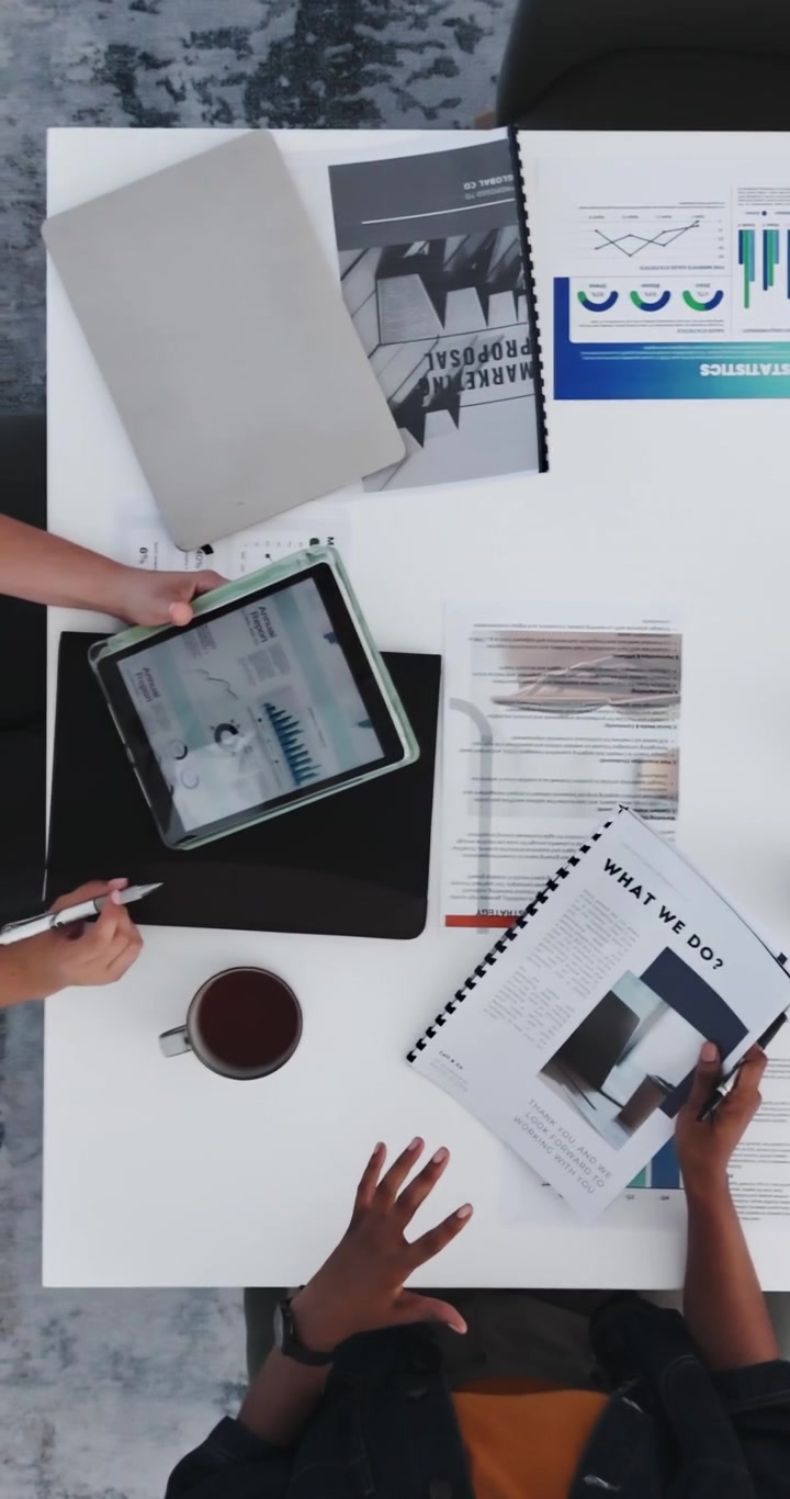 Forretningskolleger gennemgår marketingrapporter og data ved kontorbord