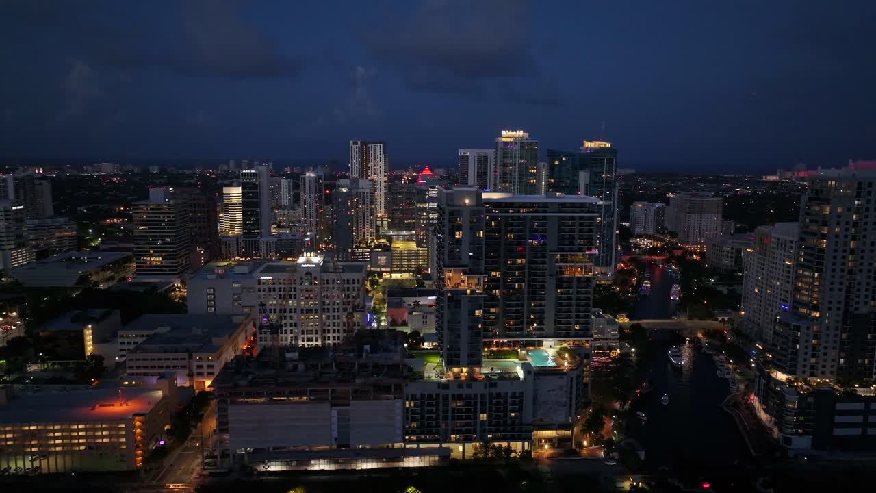 Aerial Night View of a Vibrant City Skyline with Illuminated Buildings and a River