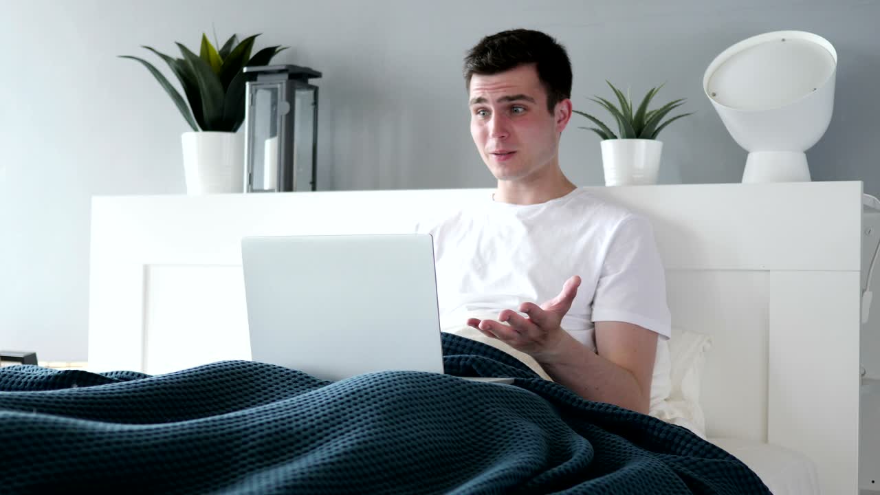 침대에서 노트북을 사용하는 슬픈 남자의 손실 반응