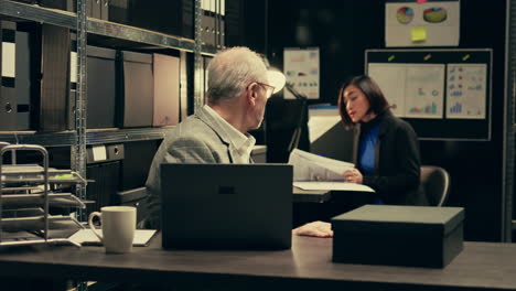 senior detective asking his partner about legal documents in archive room