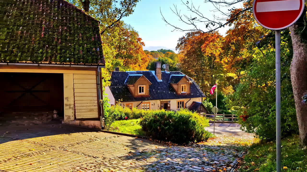 Profile view of a house with blue roof on sunny day. Countryside neighborhood