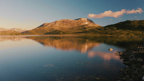 the beautiful morning light over the norwegian mountains and lake - low aerial