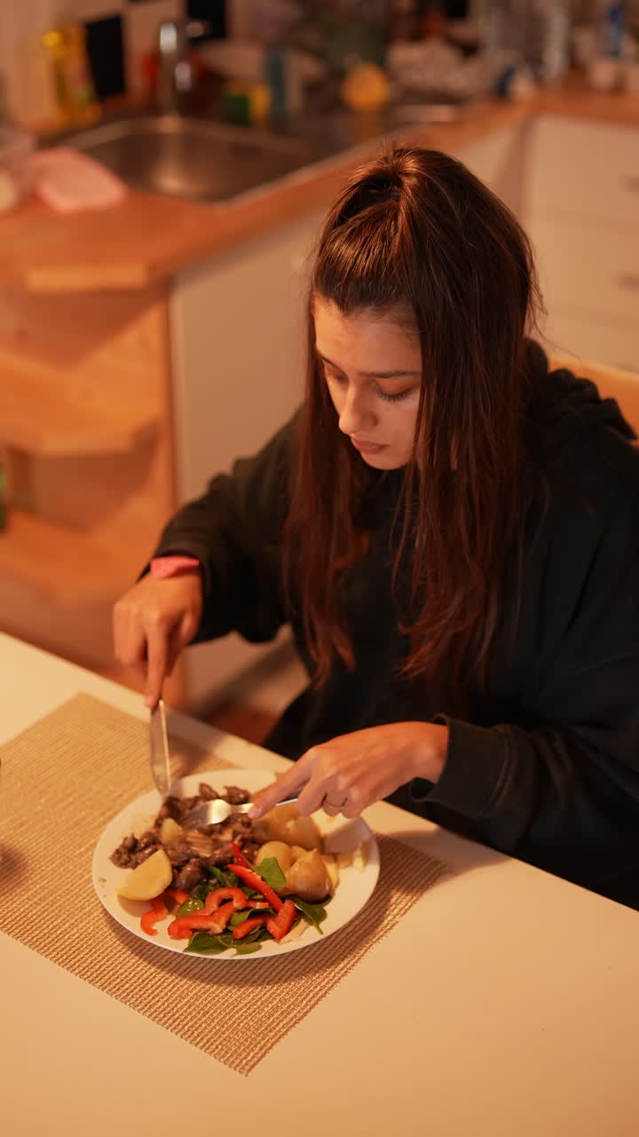una adolescente comiendo la cena.