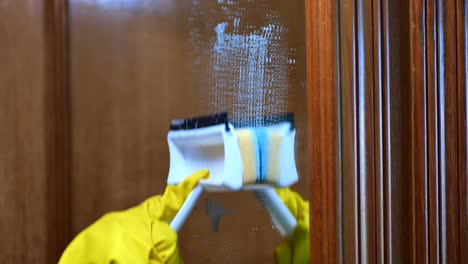 cleaning a mirror with a squeegee and sponge