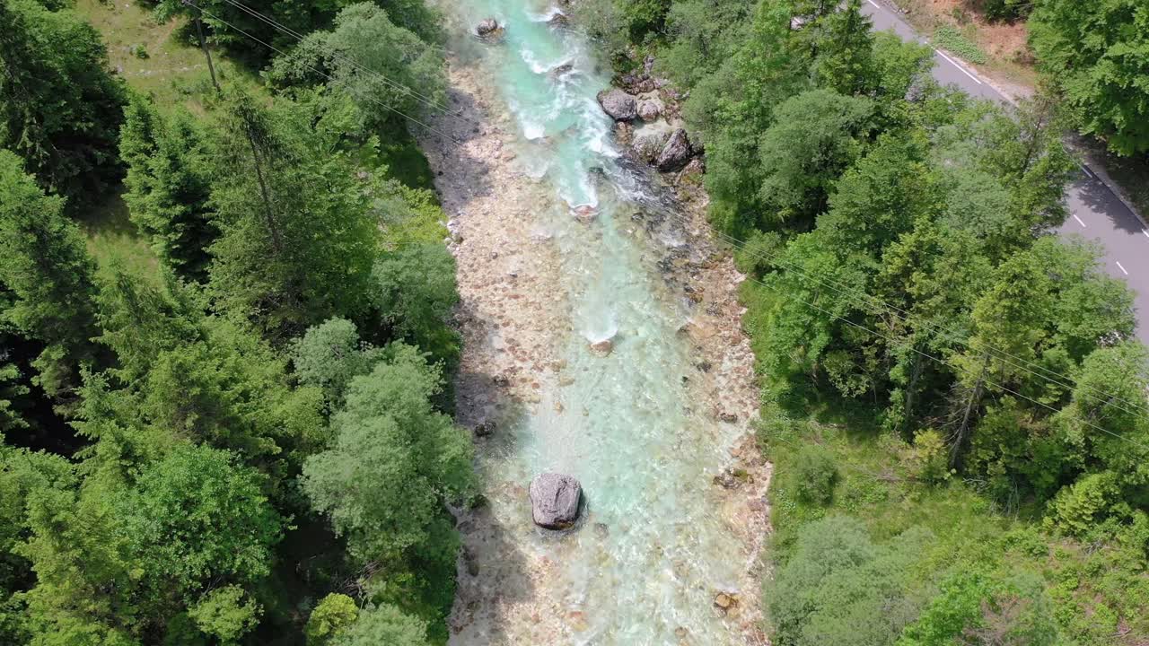 Vista aerea del fiume Isonzo trasparente che scorre accanto ai pini vicino alla cascata Boka nella Slovenia occidentale
