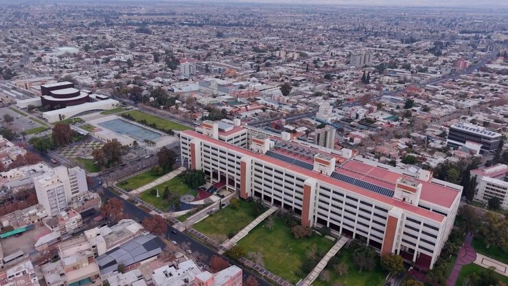 O Centro Cívico San Juan ergue-se ao longo da Avenida Libertador San Martin ao lado do Teatro Bicentenario e da Plaza Bicentenario, com a expansão urbana e as colinas da Pré-cordilheira ao fundo, órbita de drone