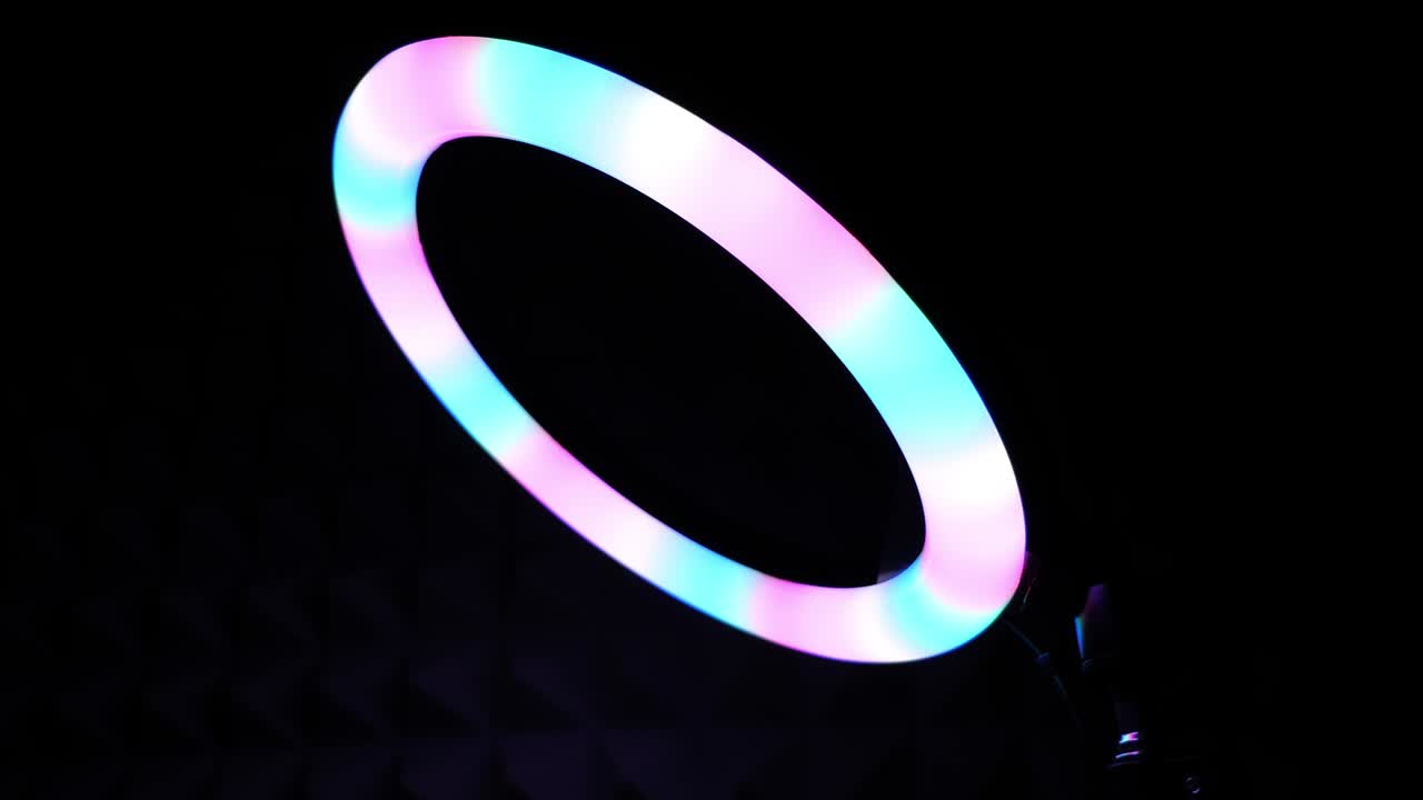 Luminous ring rgb lamp. Multicolored light in a dark room, close-up.