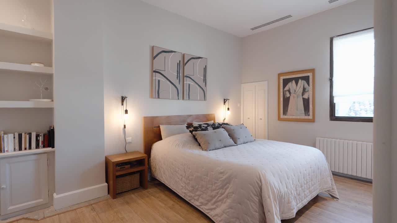 Slow revealing shot of a modern white master bedroom with a small library