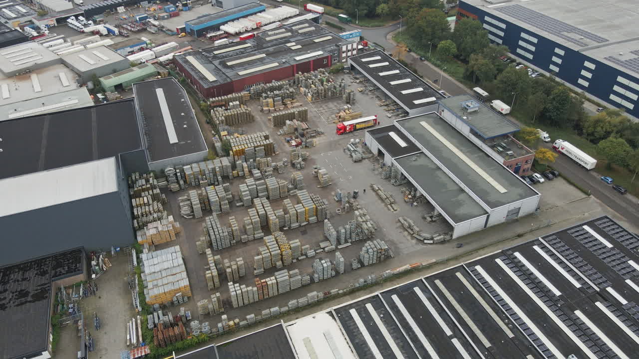 Aerial overview of an industrial storage yard filled with stacks of construction materials