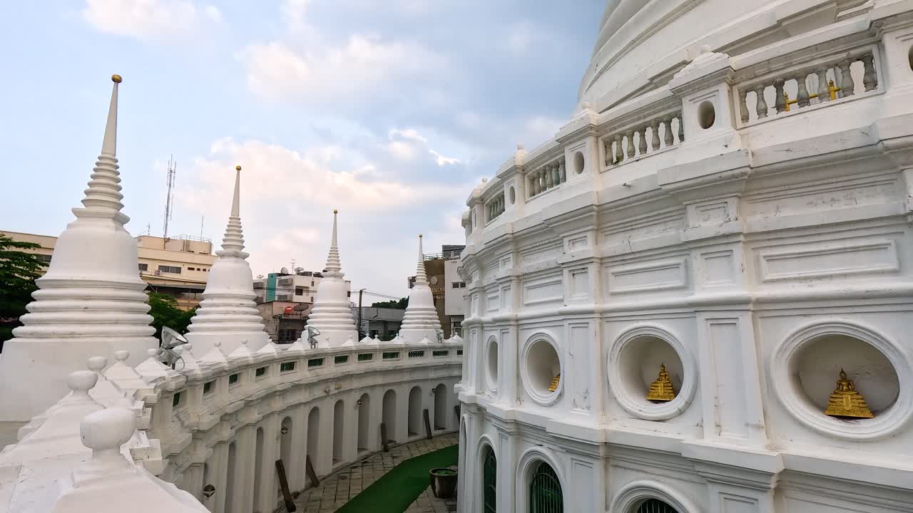 A tranquil exploration of Wat Prayurawongsawas' white stupas in Bangkok, captured in soft daylight with smooth camera movement