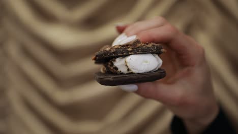 美味的自製s'more零食,女人在手中壓住s'mores