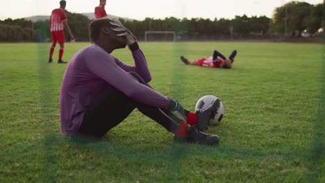 video of diverse group of male football player on field, playing football