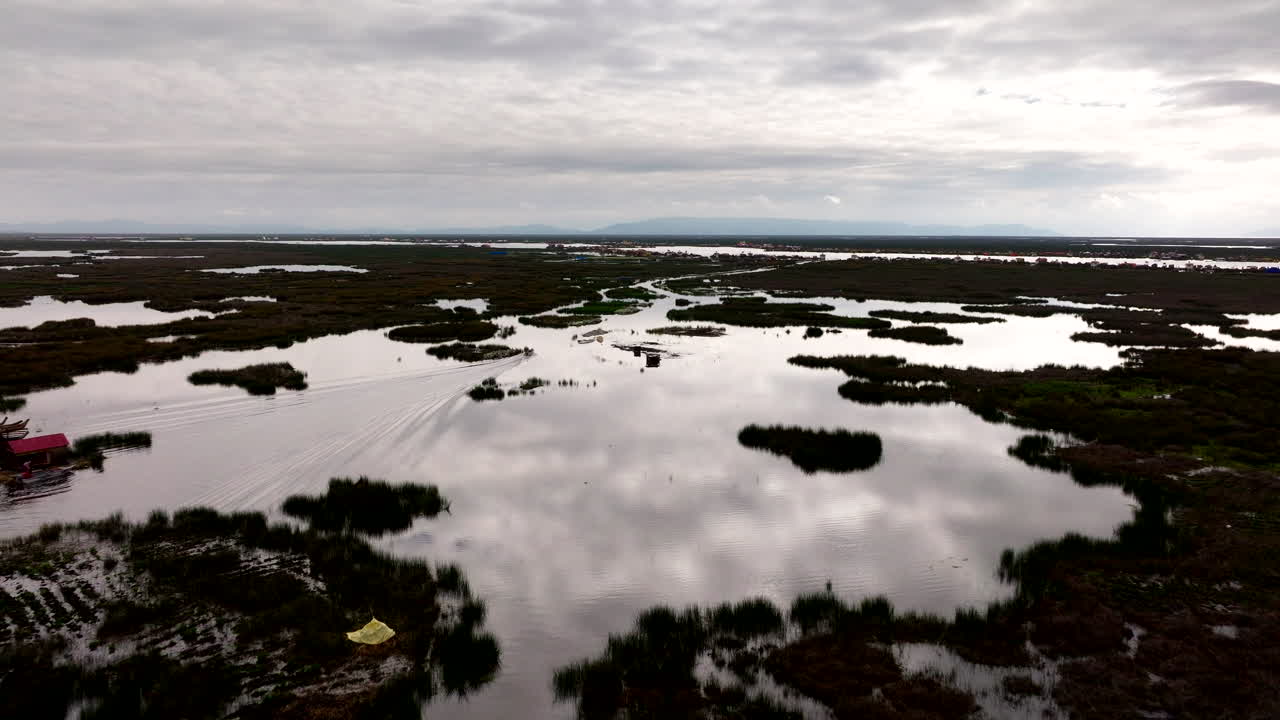 Un'imbarcazione naviga le acque del Lago Titicaca con le iconiche isole galleggianti degli Uros, vista aerea