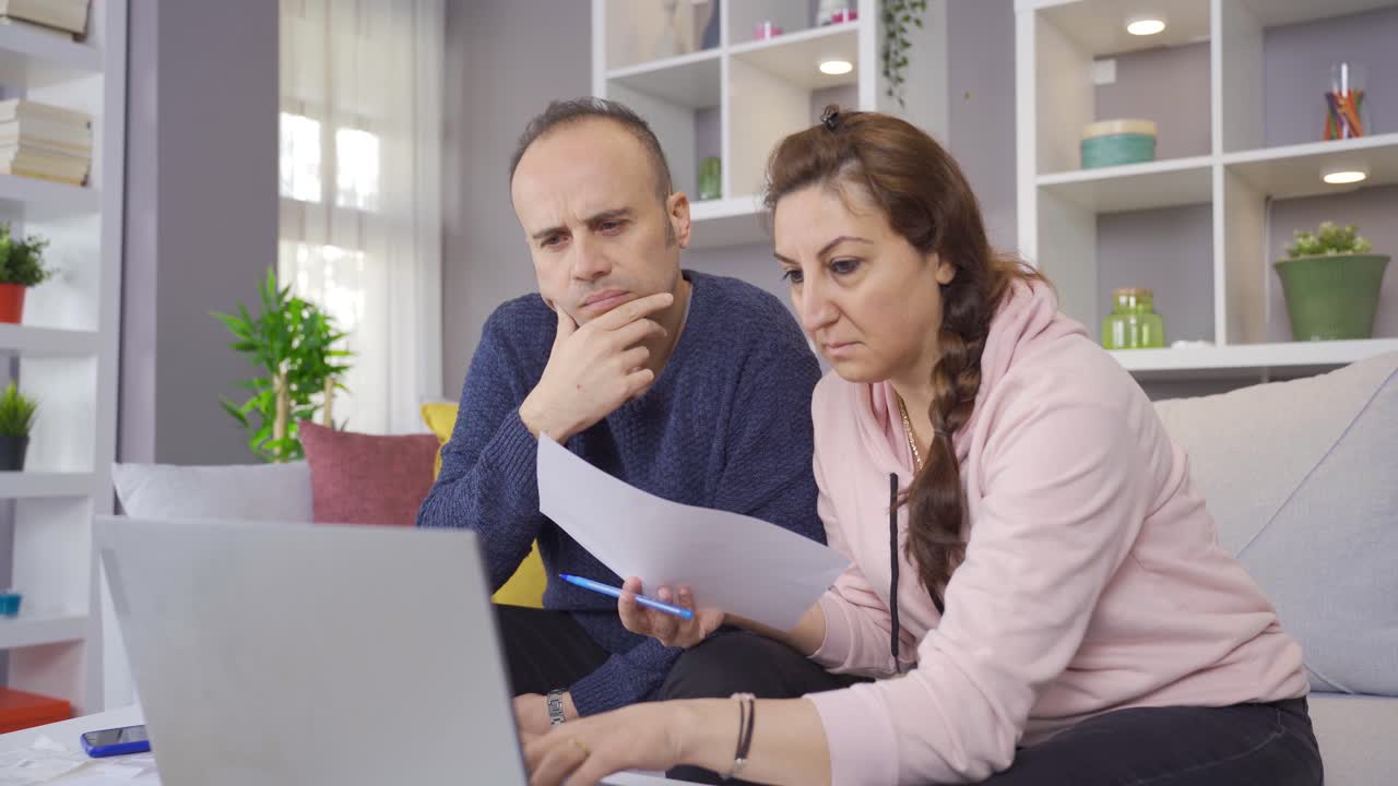 la pareja que revisa el presupuesto está revisando sus deudas y es reflexiva.