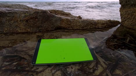 Tablet-with-green-screen-under-water-in-a-sea-pool