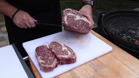 preparing raw rib eye steak for a grill